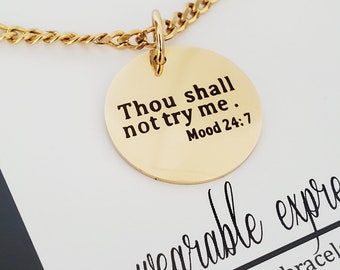 May include: Gold necklace with a round pendant that says "Thou shall not try me. Mood 24:7".