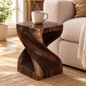 May include: A dark brown wooden side table with a twisted, hourglass-shaped base and a flat square top. The wood features a visible grain pattern with lighter and darker tones. A ceramic mug with steam sits on the table surface.