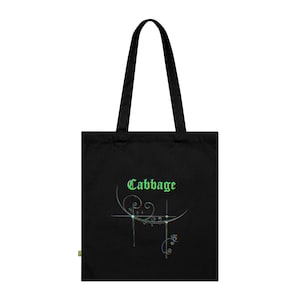 Op de afbeelding: Een zwarte tote bag met het woord Cabbage in een groen gotisch lettertype. Onder de tekst staat een dun, zilverkleurig, abstract lijnontwerp met krullende versieringen en kruisachtige accenten die een subtiel prismatisch lichteffect hebben.