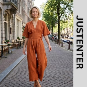 May include: A burnt orange linen jumpsuit featuring a V-neckline, wide short sleeves, and a fitted waist with side ties. The garment has wide-leg trousers and is displayed alongside the vertical text JUSTENTER on a light grey background.