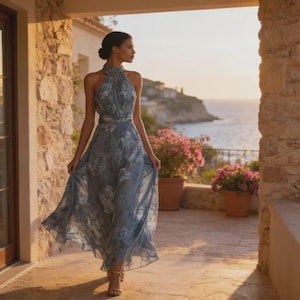 May include: A floor-length, sleeveless blue dress featuring a halter neckline and a white floral pattern. The garment has a fitted bodice with a defined waistline and a flowing, pleated skirt that reaches the ankles, crafted from a lightweight fabric.