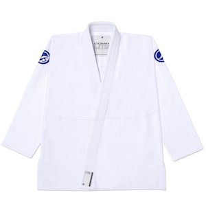 May include: A white martial arts gi jacket featuring a thick lapel, long sleeves, and blue circular logos on each shoulder. The interior neck label displays the text COMP LITE, and a small rectangular tag is attached to the bottom front hem.