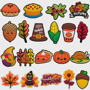 Peut inclure: Une collection de breloques en caoutchouc colorées sur le thème de l'automne et de Thanksgiving, incluant des tartes, des feuilles, une dinde, une corne d'abondance, une citrouille, un café et les textes Happy Turkey Day et Happy Thanksgiving.