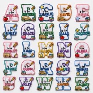 May include: A collection of twenty-six embroidered alphabet patches, each featuring a letter of the alphabet, a child's name, and school-themed icons like pencils, apples, buses, stars, globes, and stacks of books on a lined paper background.