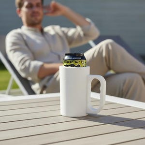 May include: A white cylindrical beverage cooler with a side handle, designed to hold a standard aluminum can. The cooler features a smooth, matte finish and a sturdy grip, providing insulation for a drink while maintaining a clean, simple aesthetic.
