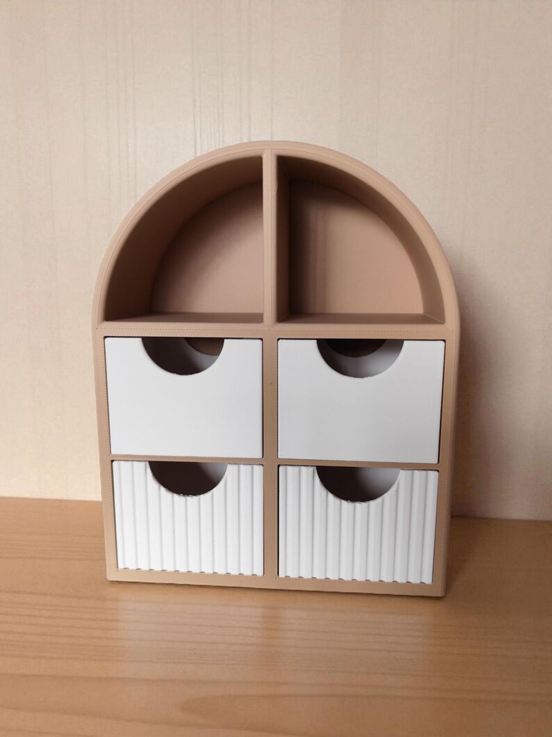 May include: A beige arched desktop organizer featuring two open top compartments and four drawers. The two upper drawers are smooth white, while the two lower drawers feature a vertical ribbed texture, each with a semi-circular cutout handle.
