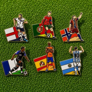 Puede incluir: Seis pines de esmalte que muestran jugadores de fútbol con uniformes de varios equipos, cada uno posicionado frente a una bandera nacional incluyendo Inglaterra, Portugal, Noruega, Francia, España y Argentina, con detalles de camisetas.