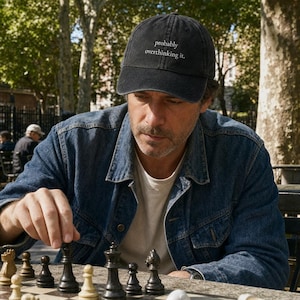 Peut inclure: Une casquette de baseball gris anthracite avec une visière courbée et le texte blanc "probably overthinking it." brodé sur le panneau avant. La casquette présente une calotte structurée, un bouton sur le dessus et un design classique à six panneaux.