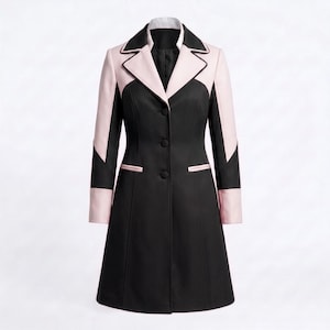 May include: A knee-length coat featuring a colour-blocked design in black and light pink. The coat has a notched lapel, long sleeves with pink cuffs, and a three-button front closure. Two horizontal welt pockets are positioned at the waist.