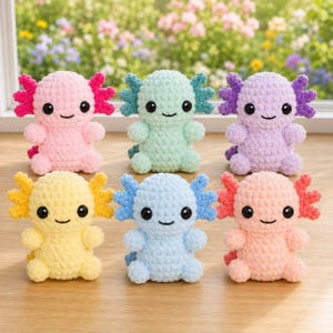 May include: Six crocheted axolotl plush toys arranged in two rows. The top row features pink, mint green, and lavender figures. The bottom row includes yellow, light blue, and peach figures. Each toy has black plastic eyes and a stitched smile.