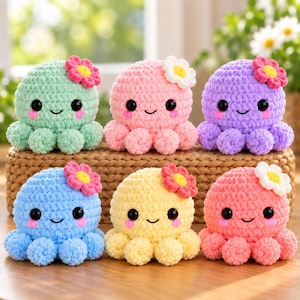 Könnte beinhalten: Sechs gehäkelte Oktopus-Plüschtiere in Minzgrün, Hellrosa, Lila, Blau, Gelb und Koralle. Jedes Stofftier hat schwarze Sicherheitsaugen, rosa Wangen, ein kleines Lächeln und eine einzelne gehäkelte Blume auf dem runden Kopf.