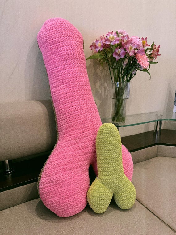 Hand-crocheted phallic pillow that walks the line between absurdist home decor and perfect bachelorette party gag — someone literally sat and stitched this with a straight face.