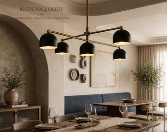 May include: A brass chandelier featuring five matte black dome-shaped shades suspended from a central rod. The fixture includes the text RUSTIC WALL LIGHTS and HANDMADE BRASS - TIMELESS DESIGN - HOME LIGHTING printed in the upper left corner.