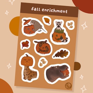 May include: A sticker sheet titled fall enrichment featuring illustrations of animals interacting with pumpkins, including a stingray, a ring-tailed lemur, a ball python, a serval cat, and a hippopotamus, alongside various autumn leaves and seeds.