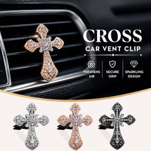 May include: A cross-shaped car vent clip featuring a metallic finish and embedded clear crystals. The design includes a central floral-like cluster and intricate filigree patterns. Three colour variations are shown: silver, rose gold, and black.