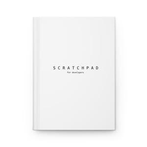 Op de afbeelding: Een wit notitieboek met een strakke omslag met de zwarte tekst SCRATCHPAD in het midden bovenaan, met de kleinere tekst For developers direct daaronder gedrukt in een eenvoudig, schreefloos lettertype.