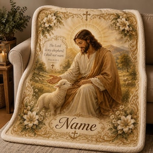 Op de afbeelding: Een crèmekleurige fleecedeken met een centrale illustratie van een bebaarde figuur in gewaden met een lam in een pastoraal landschap. De tekst luidt The Lord is my shepherd; I shall not want. Psalm 23:1 en Name, omlijst door bloemmotieven.