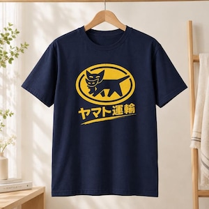 Könnte beinhalten: Ein marineblaues Kurzarm-T-Shirt mit einer gelben Grafik einer Katzenmutter, die ein Kätzchen trägt, innerhalb eines ovalen Rahmens. Unter der Grafik ist der japanische Text "ヤマト運輸" in Gelb gedruckt, unterstrichen von einem gelben Pinselstrich.