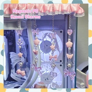 Puede incluir: Cuatro dijes colgantes verticales con cadenas plateadas, con cuentas rosas y transparentes en forma de mariposas, corazones, estrellas, lazos y flores. El texto Magnetic PC Kawaii Charms aparece en la esquina superior izquierda.
