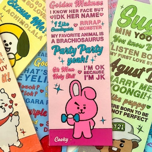 May include: A rectangular pink bookmark featuring a cartoon pink rabbit character holding a blue dumbbell. The text includes JK, JEON JUNGKOOK, Golden Maknae, I KNOW HER FACE BUT IDK HER NAME, RRRAP MONSTER, MY FAVORITE ANIMAL IS A BRACHIOSAURUS, Party Party yeah!, Oh Man Holy Shit, I'M OK BECAUSE I'M JK, and Cooky.
