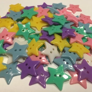 May include: A pile of colorful plastic star-shaped buttons in various pastel colors, including yellow, green, blue, purple, and pink.