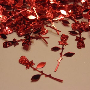 May include: A scattering of red metallic rose cutouts, some with stems and leaves, others just the rose itself. These are perfect for adding a touch of sparkle to crafts, cards, and other projects.