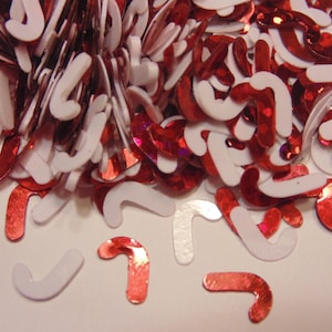 May include: A pile of red and white candy cane shaped confetti. The confetti is made of shiny red and white plastic.