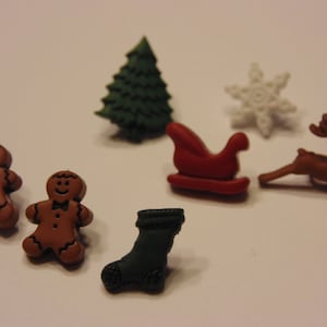May include: A collection of Christmas-themed embellishments, including gingerbread men, a Christmas tree, a snowflake, a sleigh, a reindeer, and a stocking. The embellishments are in various colors, such as brown, green, red, and white.