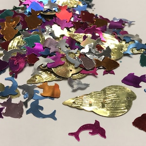 May include: Assortment of colorful metallic fish and seashell shapes. The shapes are made of shiny, reflective material and are perfect for crafts, decorations, or embellishments.