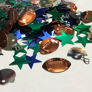 May include: A pile of green, blue, and silver metallic confetti featuring footballs, stars, and helmets.