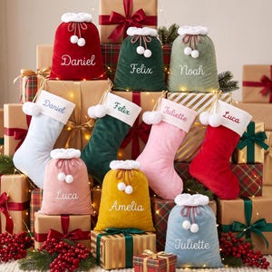 May include: A collection of velvet Christmas stockings and drawstring gift sacks in red, green, light blue, pink, and yellow. Each item features a white faux fur cuff, white pom-pom ties, and personalised names embroidered in white or coloured thread.