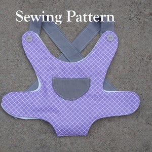 May include: A purple and white checkered baby bib with a gray pocket and gray straps. The straps cross in the back and have buttons on the shoulders. "Sewing Pattern" is written in white text at the top of the image.