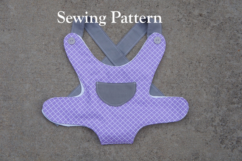 May include: A purple and white checkered baby bib with a gray pocket and gray straps. The straps cross in the back and have buttons on the shoulders. "Sewing Pattern" is written in white text at the top of the image.