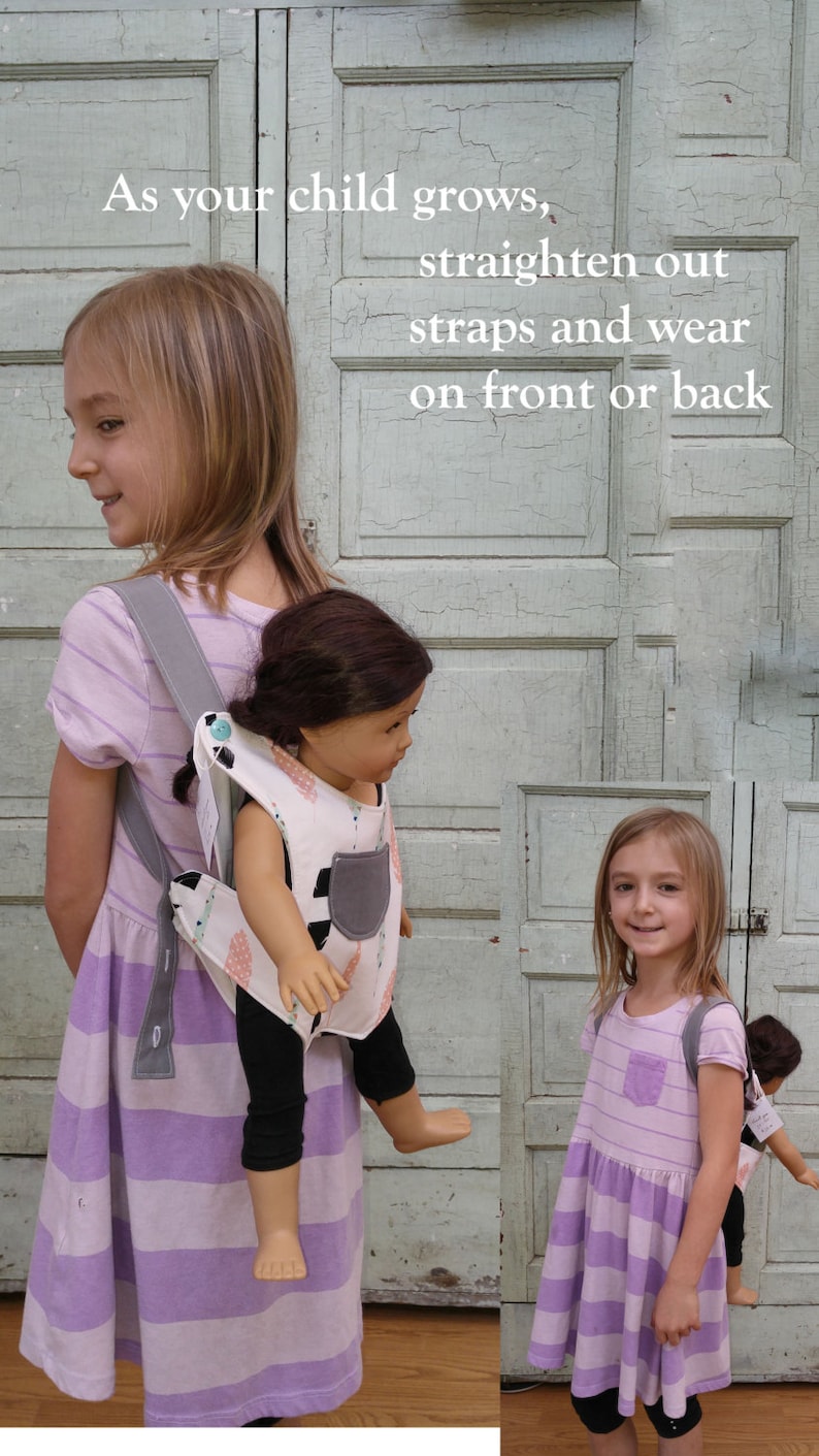 May include: Two children wearing purple and white striped dresses with adjustable straps. The straps can be worn on the front or back. One child is carrying a doll in a matching carrier.