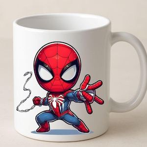 Puede incluir: Una taza de cer&aacute;mica blanca con una ilustraci&oacute;n gr&aacute;fica de un superh&eacute;roe estilo chibi, vestido con un traje rojo y azul con un emblema de ara&ntilde;a blanco en el pecho, en una postura din&aacute;mica con una mano extendida y una telara&ntilde;a detr&aacute;s.
