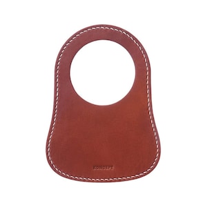 The personalized leather MiniBib, made from tan leather with white stitching, enhances the Classic Mini's design and safeguards against petrol spills