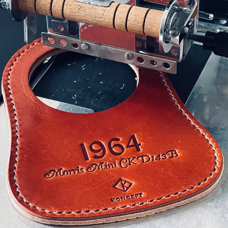 A kingsley machine personalize a tan leather fuel tank bib for a classic Mini Cooper with text 1964 and Morris Mini CK D143B