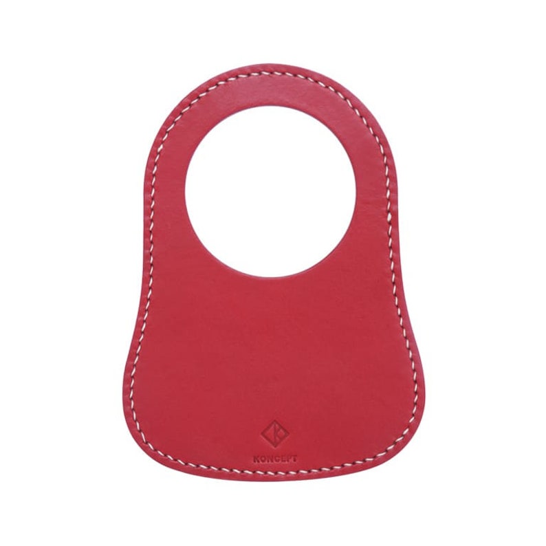 The personalized leather MiniBib, made from red leather with white stitching, enhances the Classic Mini's design and safeguards against petrol spills