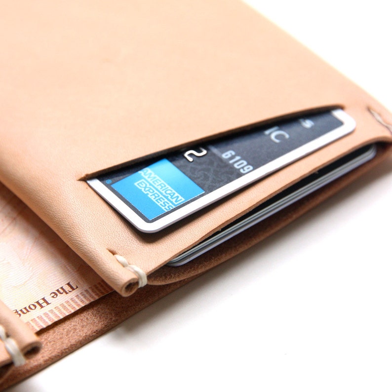 A slim, hand-stitched natural leather wallet featuring a credit card. Ideal for daily use, with compartments for bills and cards