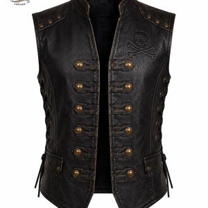 May include: A black leather waistcoat featuring a mandarin collar, two columns of five brass-toned buttons, and side lacing. The chest displays an embossed skull and crossbones emblem. The garment includes two lower pockets and decorative studs at the shoulders.