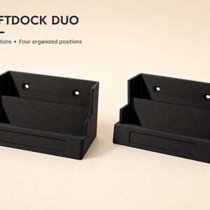 May include: Two black matte ShiftDock Duo organizers featuring two stations and four organized positions. Each rectangular unit has a tiered design with two circular mounting holes on the back panel and a recessed rectangular area on the front base.