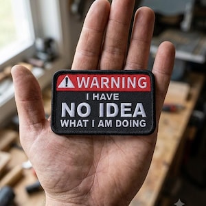 May include: A rectangular embroidered patch with a black border. The top section is red with a white exclamation point icon and the word WARNING. The bottom section is black with the white text I HAVE NO IDEA WHAT I AM DOING.
