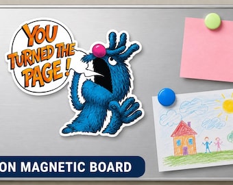 May include: A magnetic board featuring a sticker of a blue furry monster with a pink nose and a speech bubble that says YOU TURNED THE PAGE, a pink square note held by a green magnet, and a child's drawing of a house held by a blue magnet.