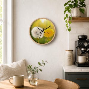 May include: A round wall clock with a light wood frame featuring a printed image of a white dandelion puff and a yellow dandelion flower, both with simple smiling faces. The clock has black hour, minute, and second hands centered on the face.
