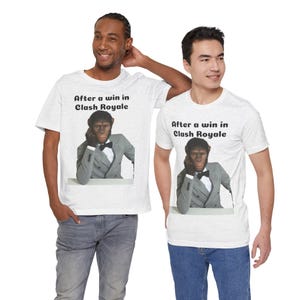 Puede incluir: Una camiseta gris jaspeado claro con un gráfico de un chimpancé con traje gris y pajarita negra, apoyando la barbilla en la mano. Sobre el chimpancé, el texto "After a win in Clash Royale" aparece en una fuente negra y negrita.