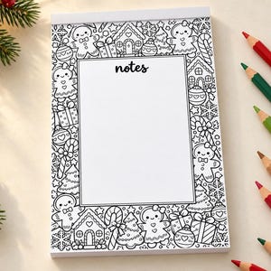 May include: A rectangular notepad with a white center and a black and white border featuring illustrations of gingerbread people, candy canes, gift boxes, and Christmas trees. The word notes is printed in black at the top of the center area.