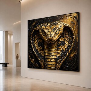 Op de afbeelding: Een groot rechthoekig wandkunstwerk met een sterk getextureerde, driedimensionale afbeelding van een kobrakop. De slang is geschilderd in metallic goud en diepzwart met dikke, zichtbare penseelstreken en een glanzende afwerking.