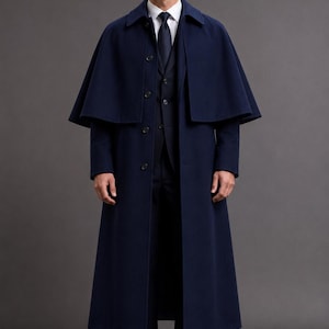 May include: A floor-length navy blue wool overcoat featuring a detachable shoulder cape, a classic collar, and a front button closure. The coat is worn over a matching navy blue suit vest, a crisp white dress shirt, and a dark navy blue necktie.