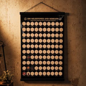 May include: A black wall-hanging poster titled 100 MILESTONES AND MISHAPS, featuring a grid of 100 hexagonal scratch-off panels. The poster includes the subtitle TRACK YOUR TABLETOP PARTY'S LEGENDARY MOMENTS and is mounted on a black wooden frame.