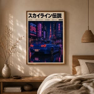 Puede incluir: Una lámina artística enmarcada que muestra un coche deportivo azul aparcado en una calle urbana mojada por la noche. La escena incluye letreros de neón con texto japonés, una torre alta al fondo y el texto japonés "スカイライン伝説" arriba.